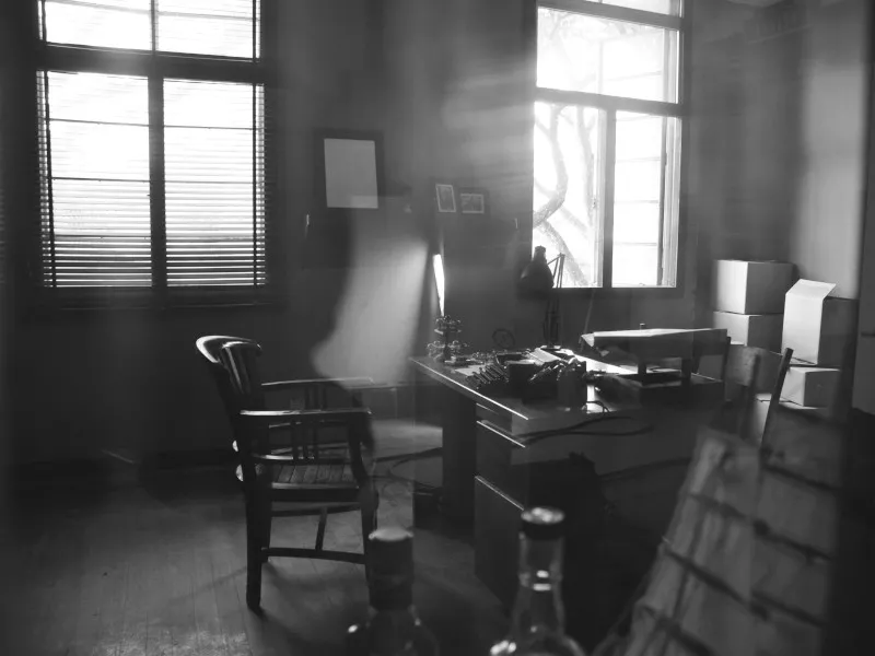 In a private investigator&#039;s office, a chair has been pushed away from a typewriter.