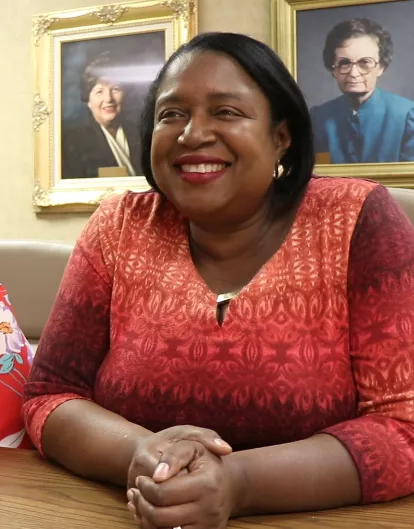 Woman smiles while sitting at a table